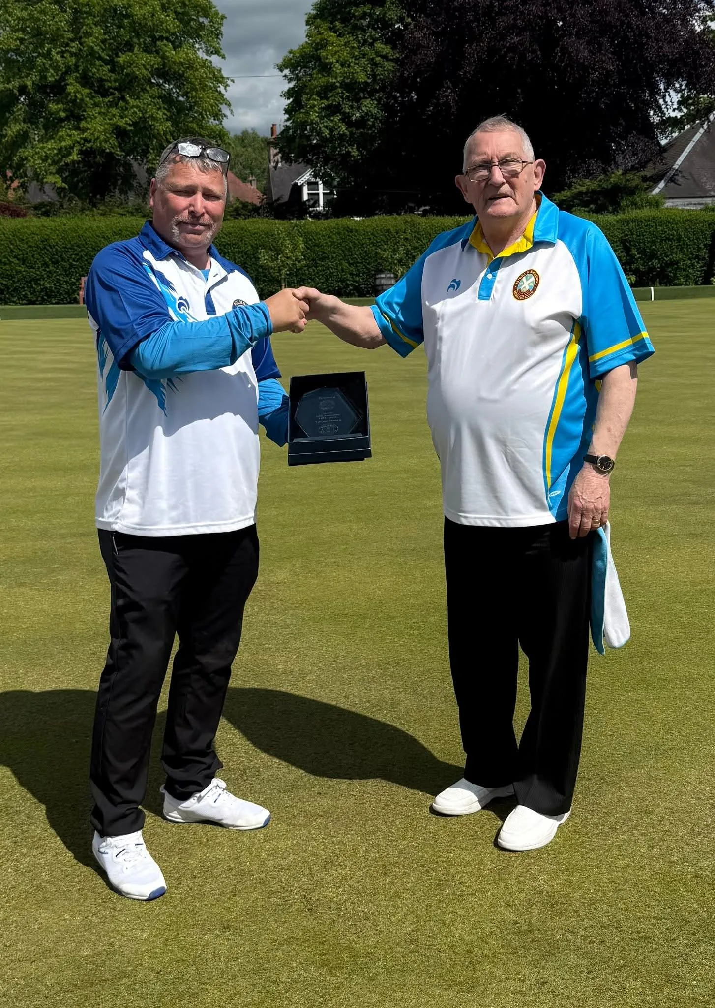 Robert Donaldson presents a commemorative plaque to Patons President H. Spence