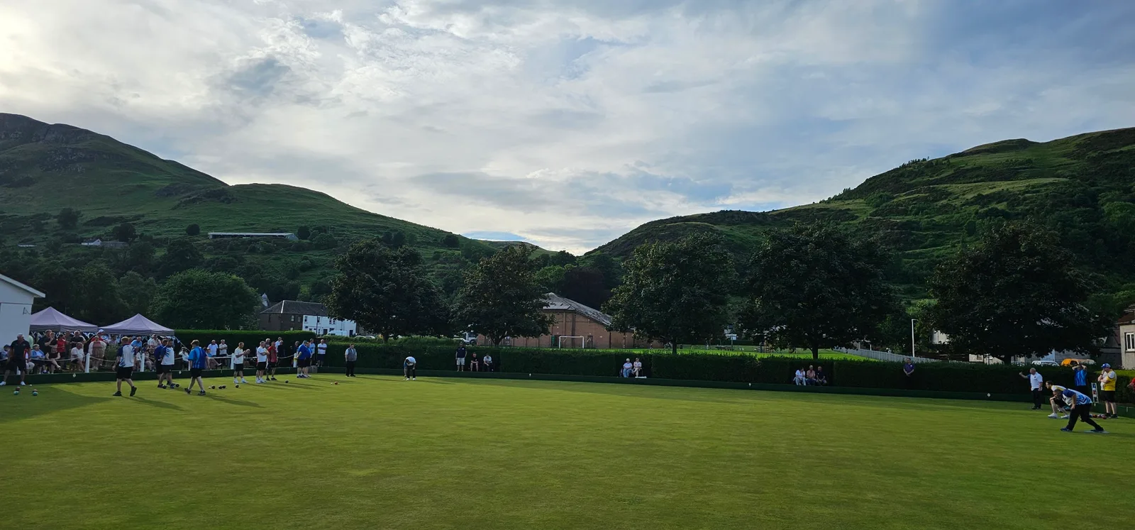 A wide shot of the bustling Menstrie Bowling Club green, capturing the fantastic atmosphere of the Area Finals