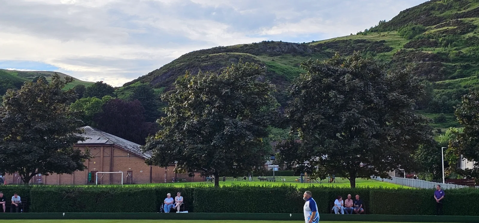 The stunning backdrop of the Ochil Hills overlooking the green, providing a beautiful and dramatic setting for the evening's matches